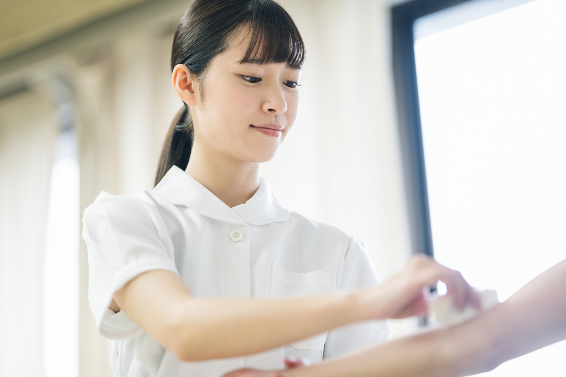 白衣の職員が患者に対応している場面。介護施設の医療サービスの様子。